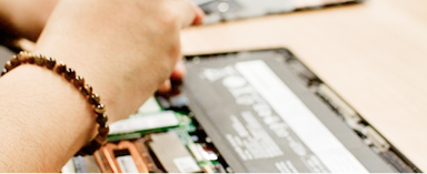 close up of hands of person fixing a laptop computer