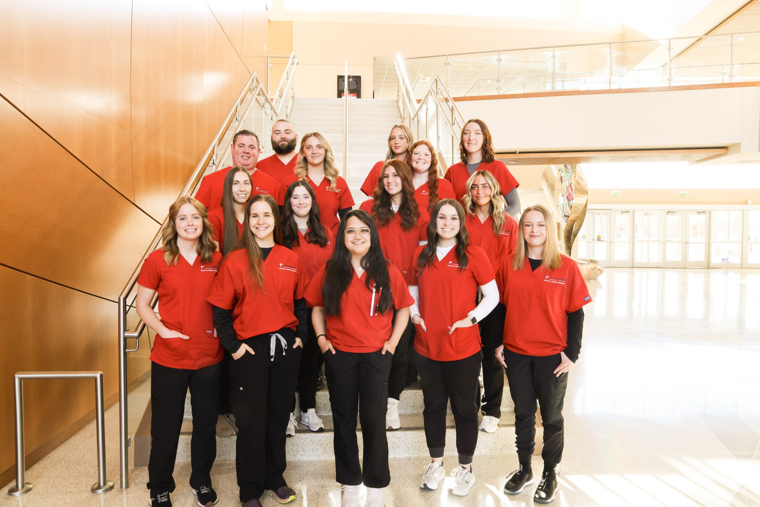 Practical nursing students posing for a group picture on a set of stairs.