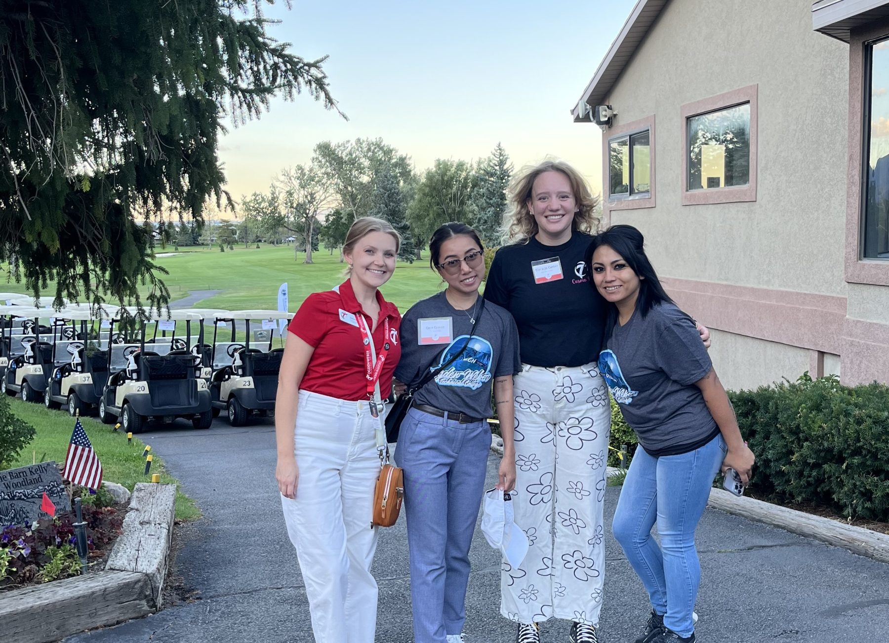 Four OTECH employees standing together outside near golf carts during the 19th annual Student Success Golf Tournament.