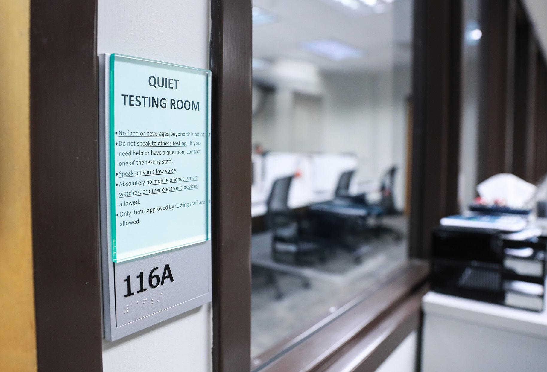 Quiet Testing Room sign at the entrance to room 116A with testing rules listed, workstations visible in background