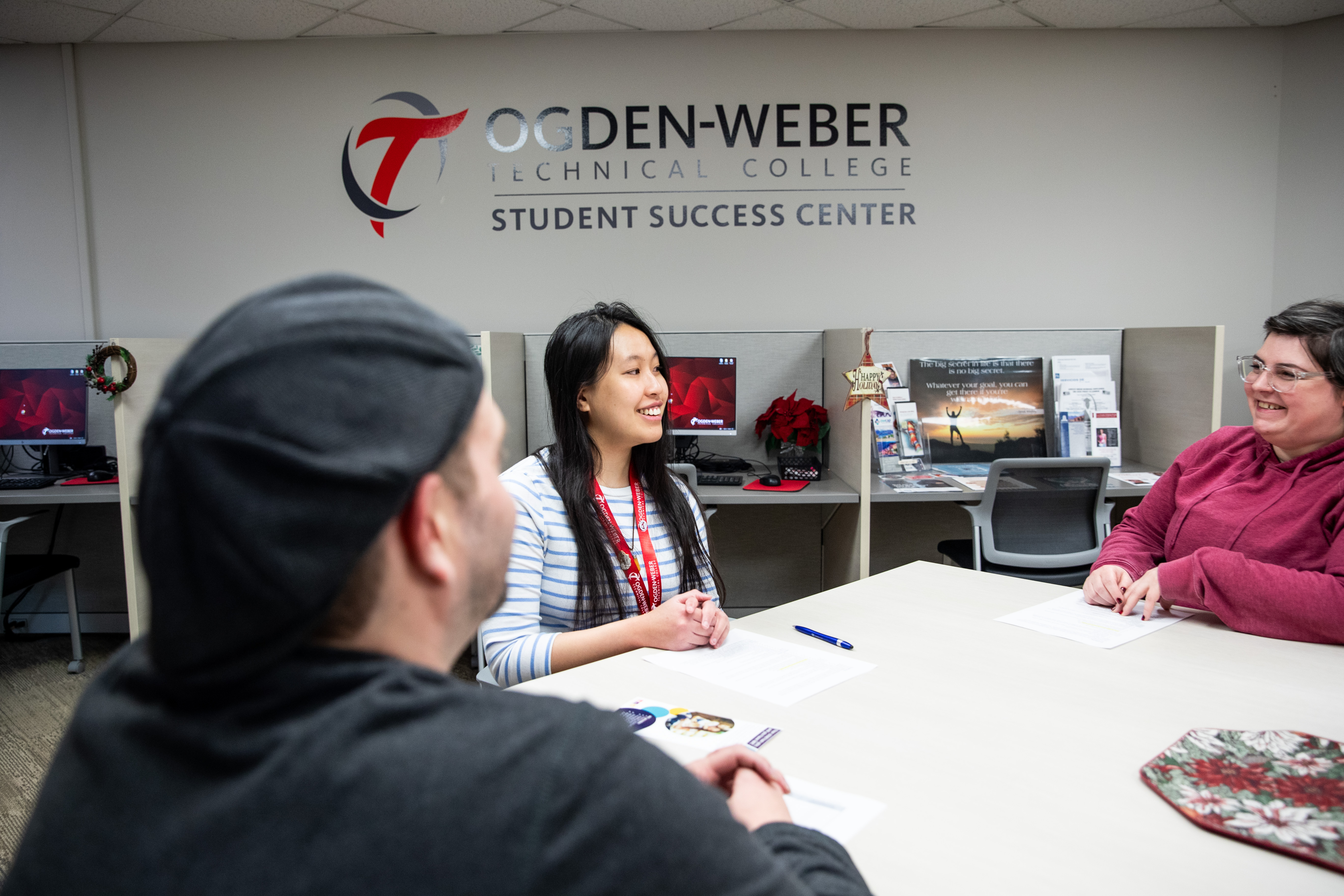 Ogden-Weber Technical College Student Success Center advisor meeting with two students at a table