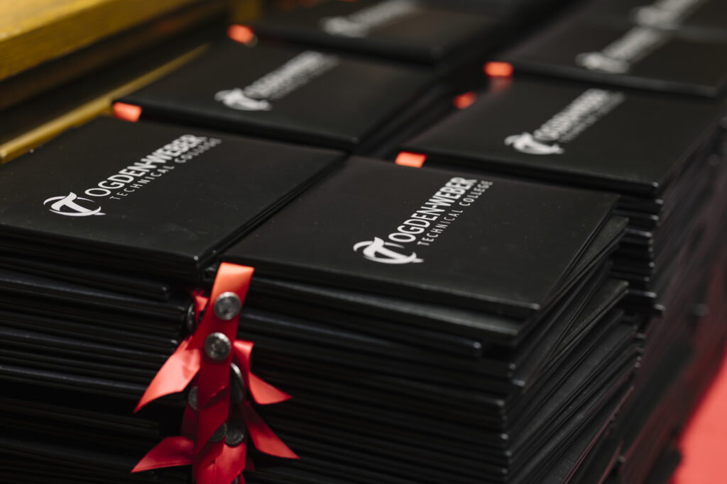 Stack of black keyboards tied with red ribbons, arranged for display in a store or showroom.